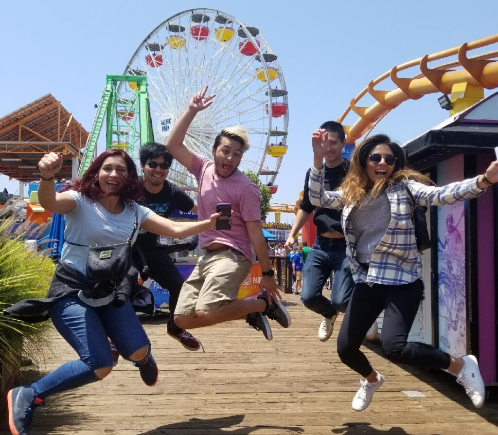 A Los Angeles scavenger hunt team jumps on the Santa Monica Pier for a photo challenge.