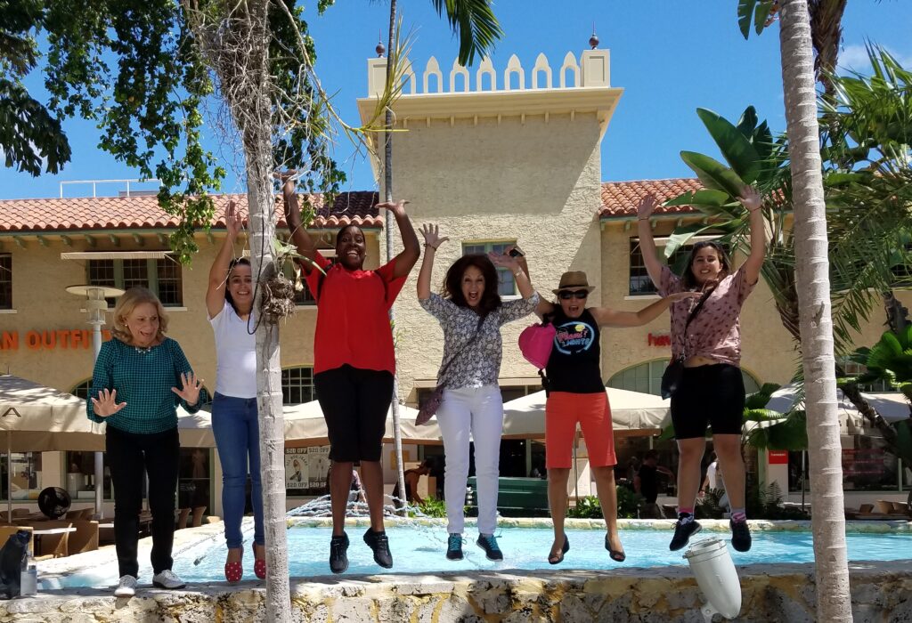 Players on a corporate scavenger hunt in Miami taking a photo jumping in the air in South Beach.