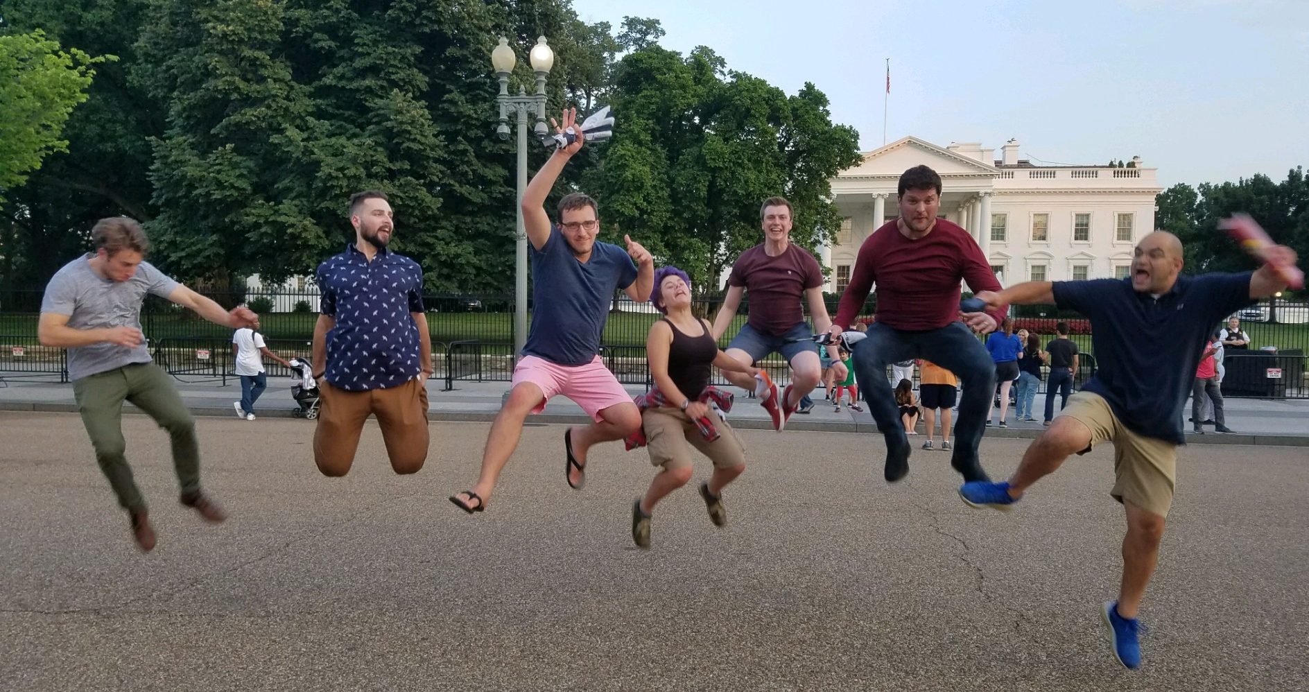 People on a scavenger hunt in Washington DC pose for a photo challenge in front of the White House.