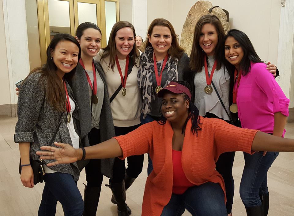 all-women team of scavenger hunt participants wearing medals after a team-building game
